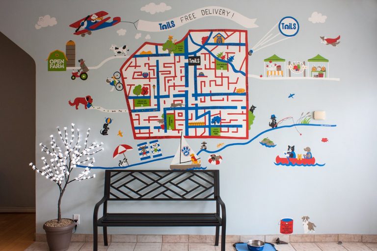 A mural depicting a painted map of East York's major intersections with a red border. Cartoon dogs bike, swim, fish and drive around map.