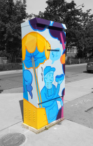 The front face of the Huron St & Harbord St signal box, featuring a painted man holding a hot dog.