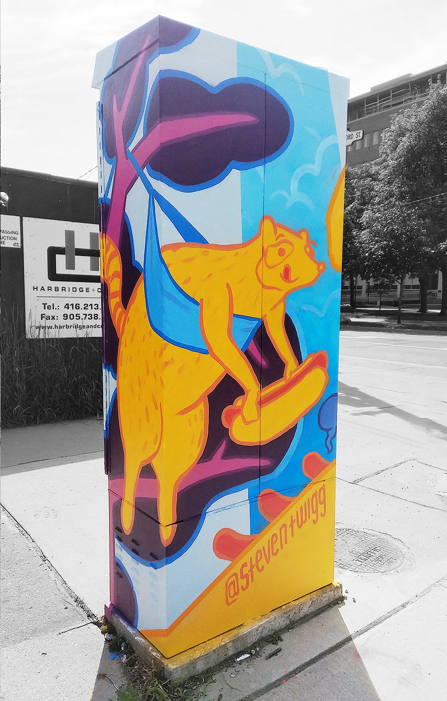 The rear face of the Huron St & Harbord St signal box, featuing a cartoonishly painted raccoon holding a hot dog.