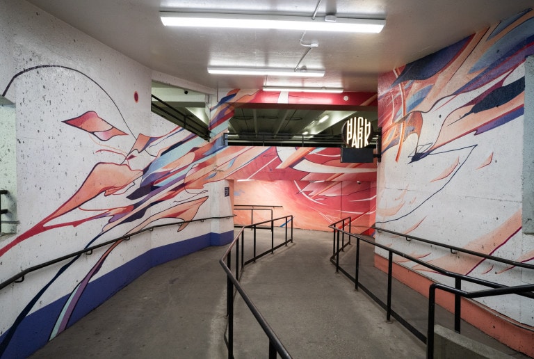 Abstract colours and fluid linework with pinks and purples. Lit up High Park round sign on right side.