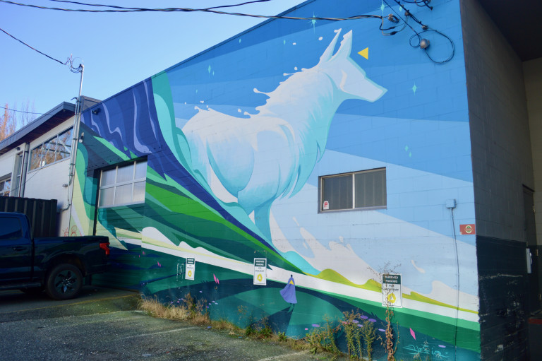 A prominent dog depicted along a mountain, in a minimalist landscape, surrounded by cool colours