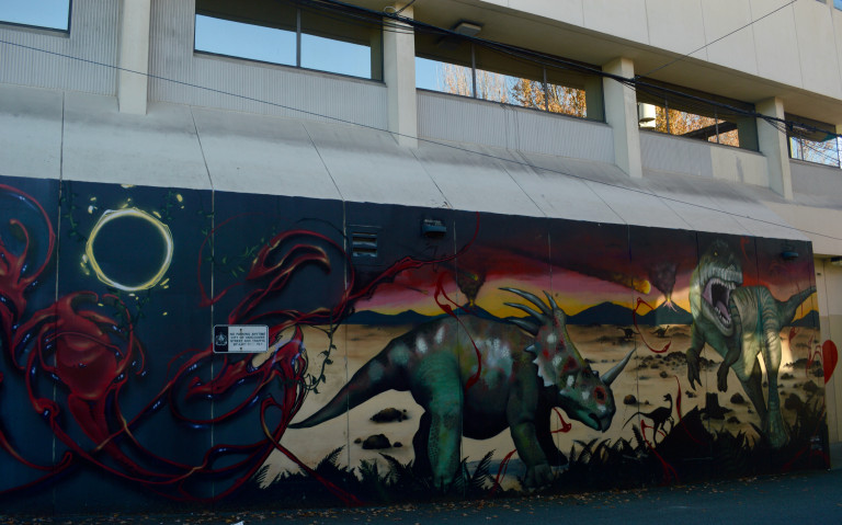 A scene from Jurassic park is depicted on a outdoor wall.