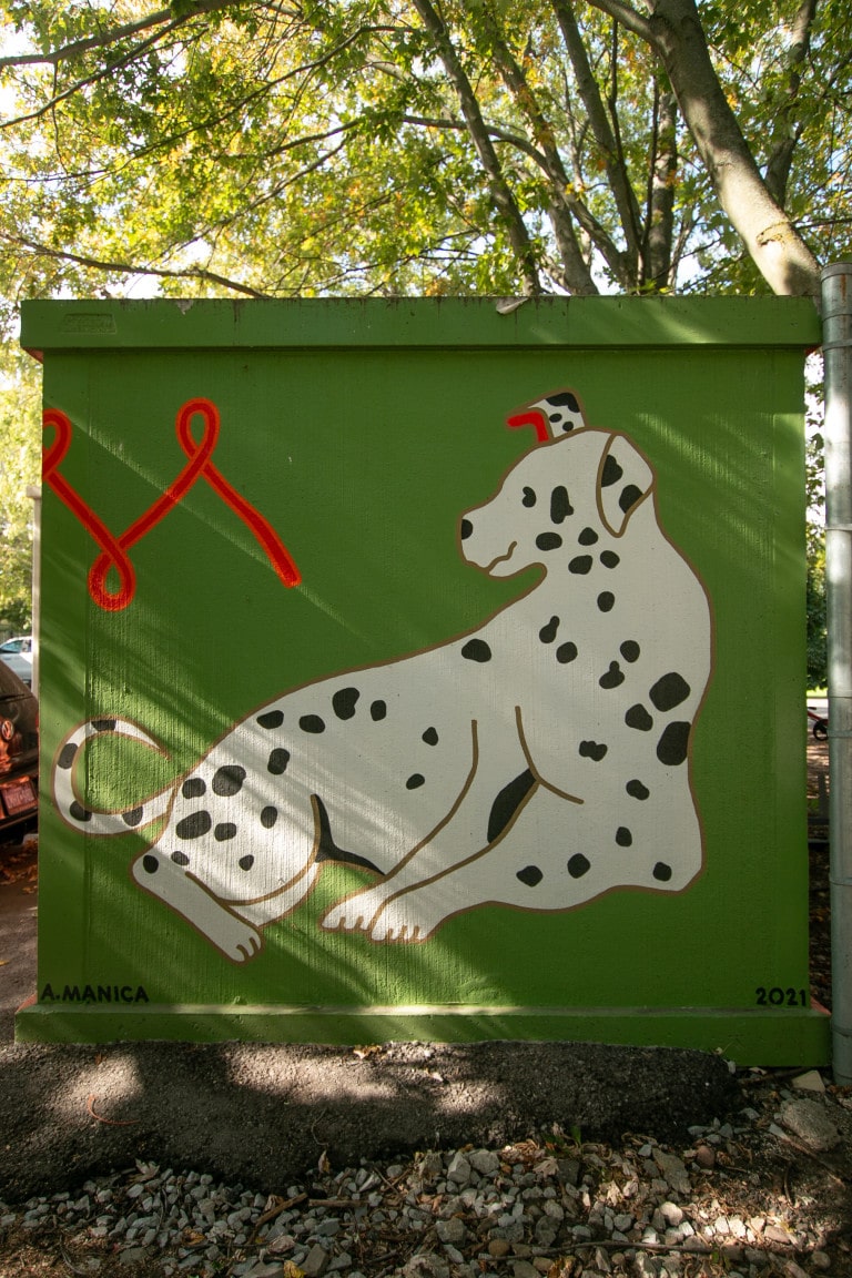 Photo of a side of a painted bunker featuring a Dalmatian in odd proportions on a green background.