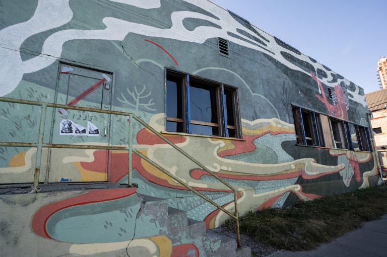 Grass with blobs of flowing liquid floating in air. Girl kneeled on the ground on the right side trying to catch the dripping white liquid.