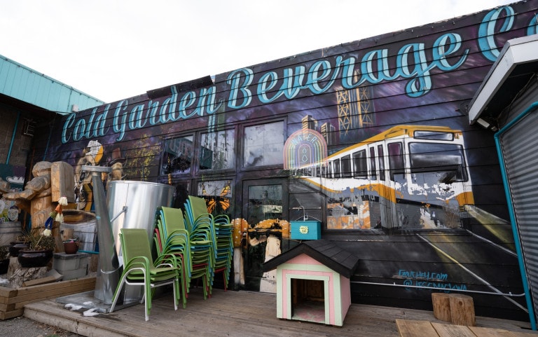 C-train in yellow and white with text "Cold Beverage Garden" above in a spacey coloured background.