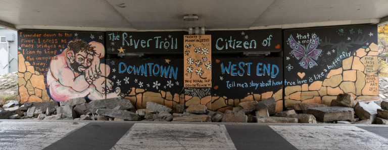 From left to right. A naked man in fetal position surrounded by broken rocks and purple moth flying in air on right side. Text surrounds characters.