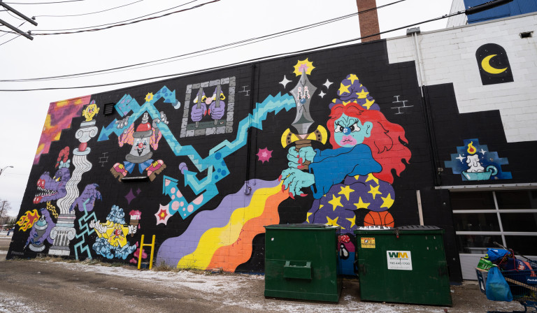 Witch sitting on a basketball shooting rainbow out of hand and holding sword in other. Blue laser shoots from sword towards monsters on left side.