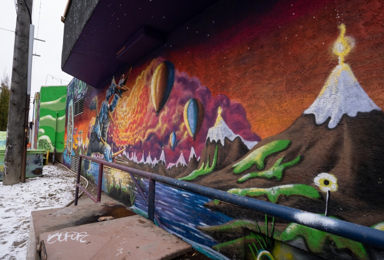 Mountains on right side, hand puppet on left side with feathery blue birds on each finger.