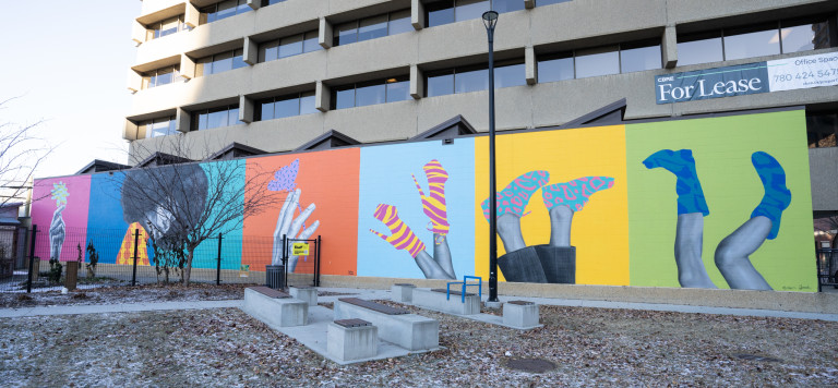 6 different squared sections with different colours. Left to right. Section 1: Hand holding flower. Section 2: Woman with afro in orange and yellow diamond patterned top. Section 3: butterfly on hand. Section 4:  legs upside down with striped yellow and pink high heels. Section 5: upside down legs with blue and hot pink runners. Section 6: upside down legs with blue and dark blue patterned boots.