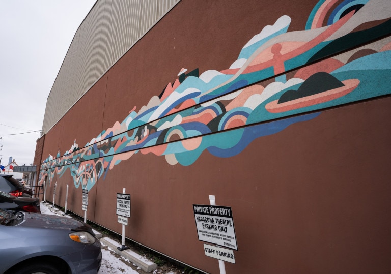 Different shapes and colours flowing across wall resembling landscape scenery.