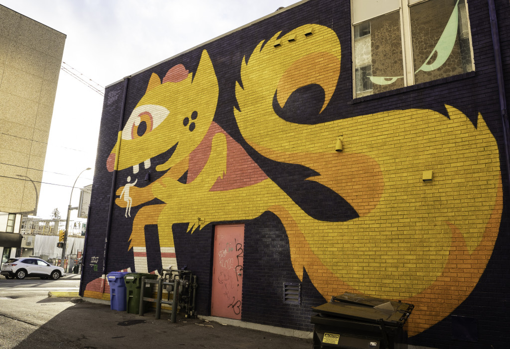 Giant squirrel holding a stick person in hand. Squirrel wearing pink cap, pink shirt and pink sneakers. Sitting on top of pink door.
